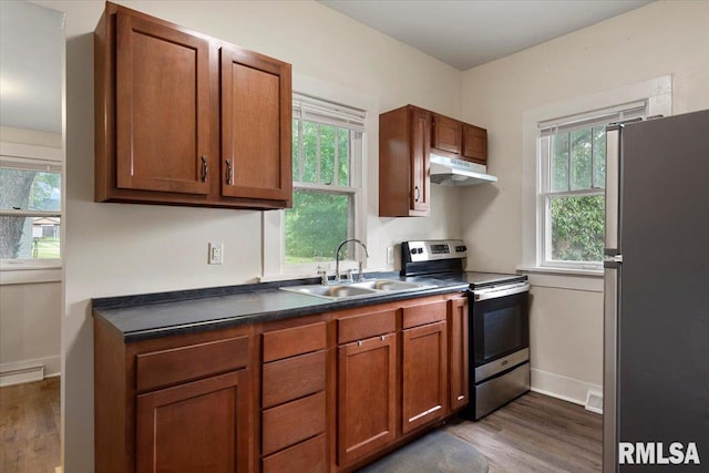 708 E 5th St, Pana, IL 62557 - kitchen with stainless steel appliances, under cabinet range hood, dark wood-type flooring, and dark countertops