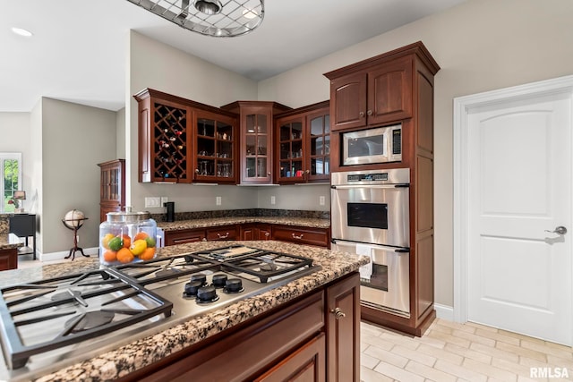 4901 Wildcat Run, Springfield, IL 62711 - kitchen with stainless steel appliances, glass insert cabinets, baseboards, and stone counters