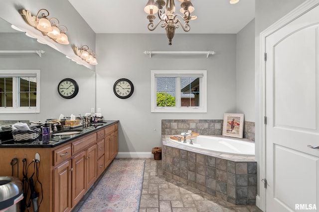 4901 Wildcat Run, Springfield, IL 62711 - full bathroom with stone tile flooring, a garden tub, double vanity, baseboards, and a chandelier