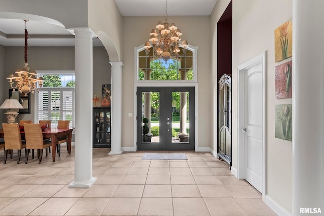 4901 Wildcat Run, Springfield, IL 62711 - entrance foyer featuring a chandelier, ornate columns, arched walkways, a towering ceiling, and light tile patterned floors