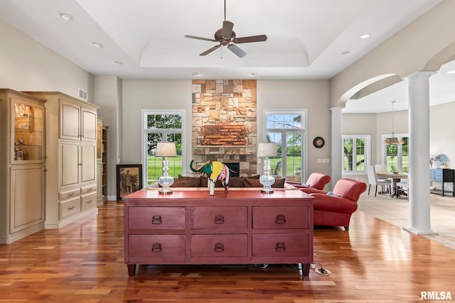 4901 Wildcat Run, Springfield, IL 62711 - living area featuring ornate columns, a fireplace, a ceiling fan, wood finished floors, and a raised ceiling