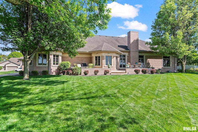 4901 Wildcat Run, Springfield, IL 62711 - back of house with brick siding, a lawn, a chimney, and a patio area