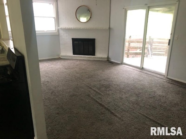 1522 Rim Rd, Quincy, IL 62305 - unfurnished living room featuring carpet, baseboards, and a brick fireplace