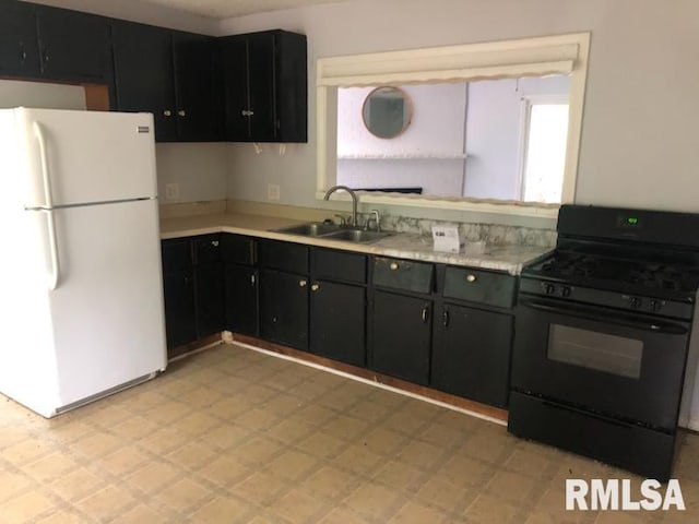 1522 Rim Rd, Quincy, IL 62305 - kitchen with freestanding refrigerator, black gas range oven, a sink, light floors, and light countertops