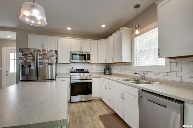801 S 22nd St, Quincy, IL 62301 - kitchen with stainless steel appliances, a sink, white cabinets, tasteful backsplash, and light wood finished floors