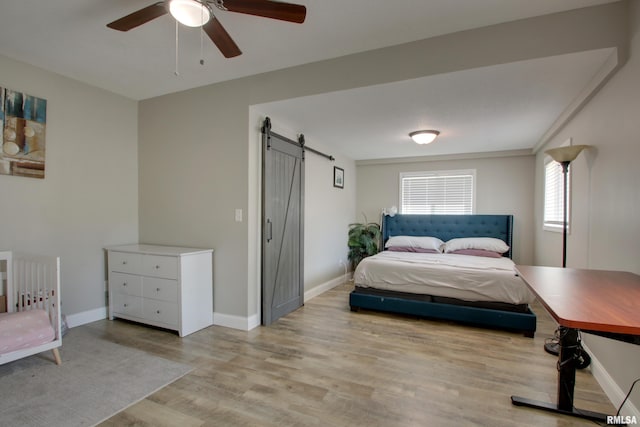 801 S 22nd St, Quincy, IL 62301 - bedroom featuring a barn door, light wood-type flooring, baseboards, and ceiling fan