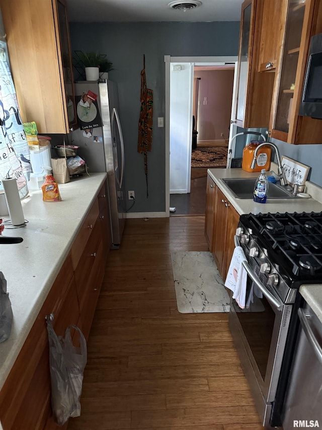 2853 Hoover Ave, Springfield, IL 62703 - kitchen featuring brown cabinetry, appliances with stainless steel finishes, a sink, dark wood-style flooring, and light countertops