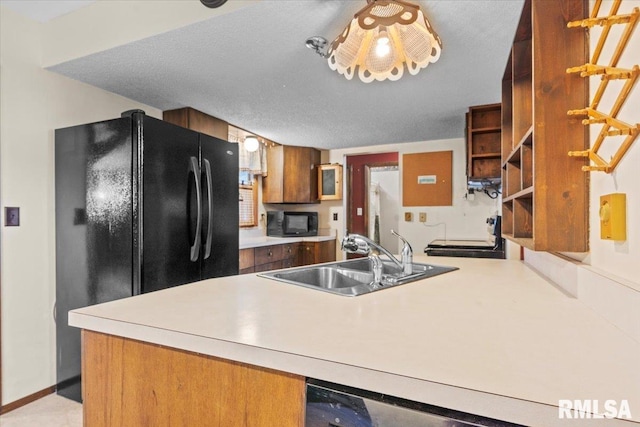 34831 Greenland Rd, Virden, IL 62690 - kitchen featuring black appliances, a sink, brown cabinetry, open shelves, and a peninsula