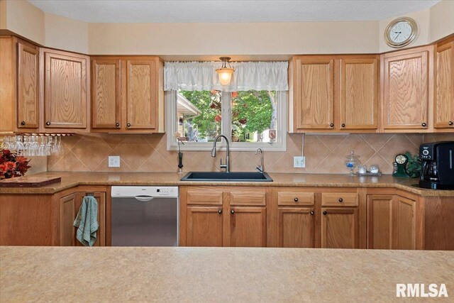 4 Nightingale Dr, Springfield, IL 62711 - kitchen with stainless steel dishwasher, a sink, backsplash, and light countertops