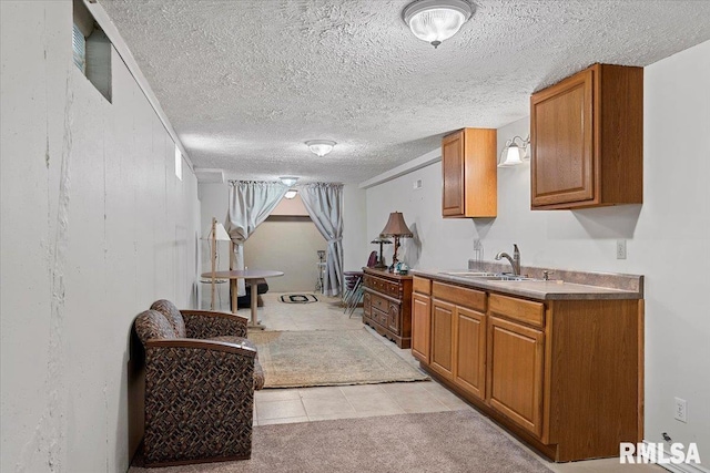 4 Nightingale Dr, Springfield, IL 62711 - kitchen with a sink, brown cabinetry, a textured ceiling, and light tile patterned flooring