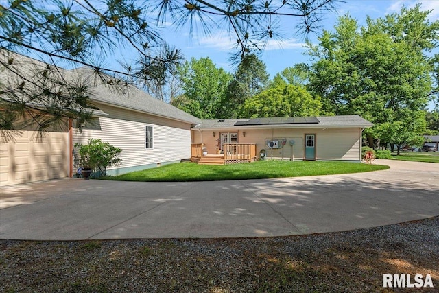 4 Nightingale Dr, Springfield, IL 62711 - back of house with driveway, solar panels, a lawn, and a deck