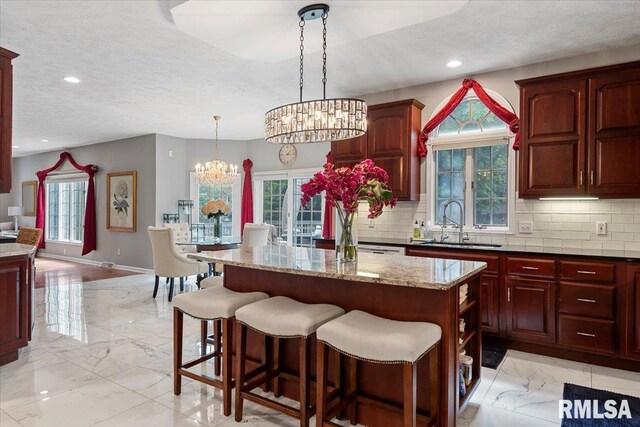 505 Clipper Rd, Springfield, IL 62704 - kitchen featuring light marble finish floors, a sink, a chandelier, a textured ceiling, and tasteful backsplash