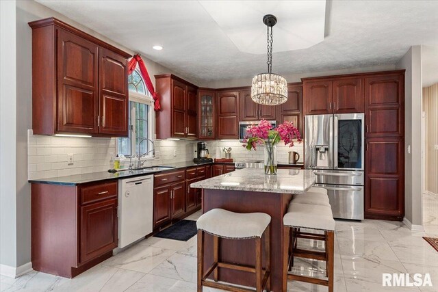 505 Clipper Rd, Springfield, IL 62704 - kitchen with stainless steel appliances, light marble finish flooring, reddish brown cabinets, a chandelier, and recessed lighting