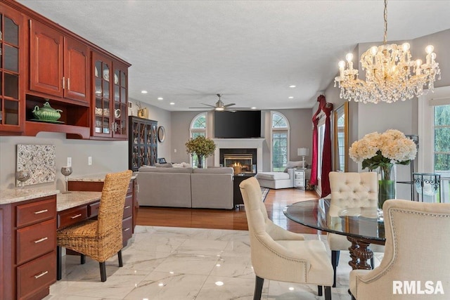 505 Clipper Rd, Springfield, IL 62704 - dining area with ceiling fan, a chandelier, light marble finish floors, a glass covered fireplace, and recessed lighting