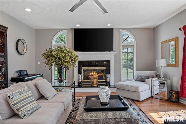 505 Clipper Rd, Springfield, IL 62704 - living room with wood finished floors, a ceiling fan, a textured ceiling, recessed lighting, and a glass covered fireplace