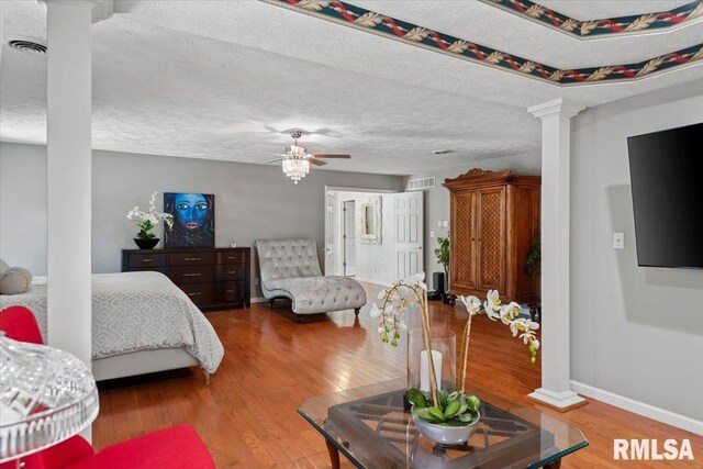 505 Clipper Rd, Springfield, IL 62704 - bedroom with decorative columns, wood finished floors, baseboards, and a textured ceiling