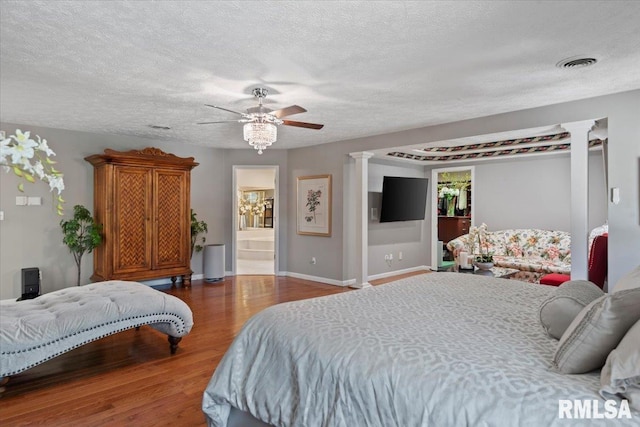 505 Clipper Rd, Springfield, IL 62704 - bedroom with decorative columns, wood finished floors, baseboards, a textured ceiling, and ensuite bath