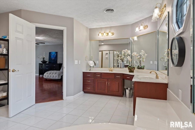 505 Clipper Rd, Springfield, IL 62704 - ensuite bathroom featuring a textured ceiling, tile patterned flooring, double vanity, and baseboards