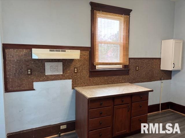 412 Pine St, Greenfield, IL 62044 - kitchen with under cabinet range hood, tile walls, a wainscoted wall, light countertops, and white cabinetry