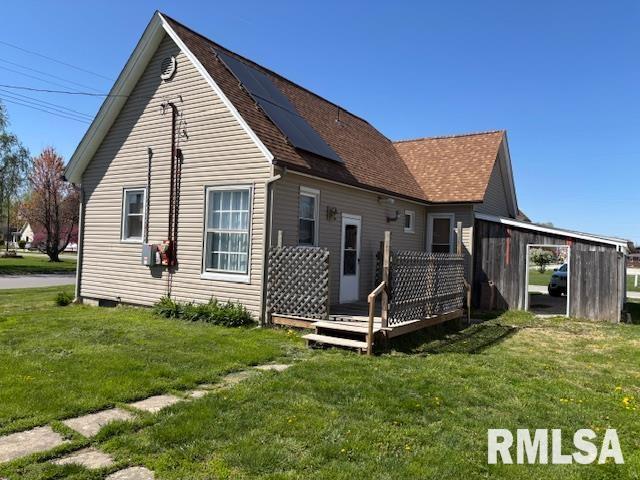 412 Pine St, Greenfield, IL 62044 - back of house featuring a lawn, a wooden deck, roof with shingles, and solar panels