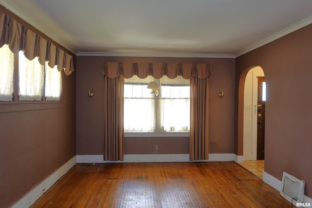 345 Division St, Galesburg, IL 61401 - spare room featuring arched walkways, plenty of natural light, hardwood / wood-style flooring, ornamental molding, and baseboards