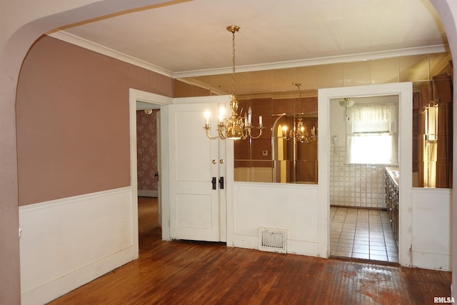 345 Division St, Galesburg, IL 61401 - unfurnished dining area featuring a chandelier, hardwood / wood-style flooring, arched walkways, and crown molding