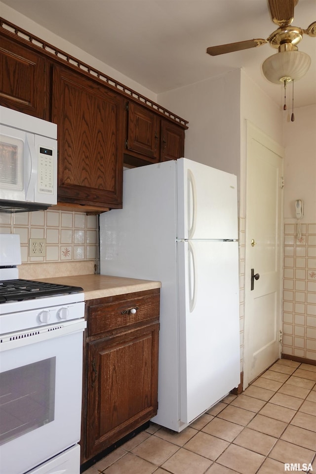 345 Division St, Galesburg, IL 61401 - kitchen featuring white appliances, light countertops, light tile patterned floors, dark brown cabinetry, and backsplash