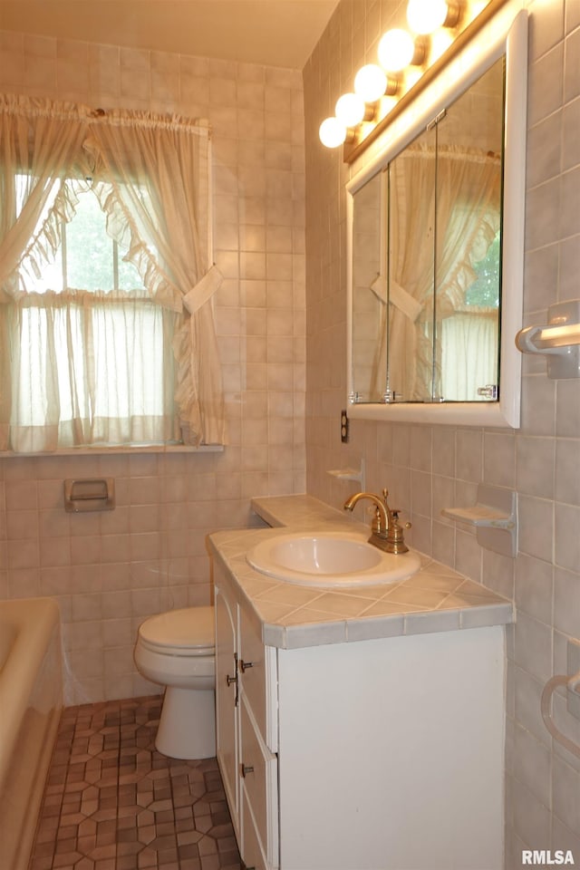 345 Division St, Galesburg, IL 61401 - full bath featuring tile walls, toilet, vanity, backsplash, and tile patterned floors