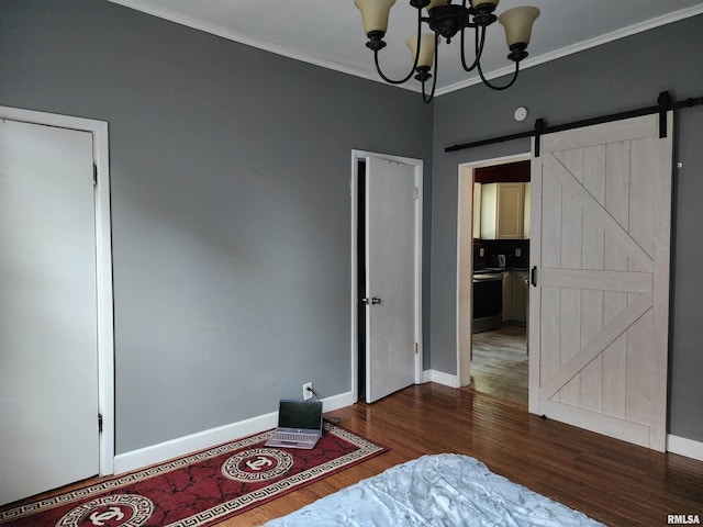 bedroom featuring wood finished floors, a barn door, a chandelier, crown molding, and baseboards