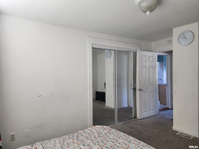 carpeted bedroom with a closet and baseboards