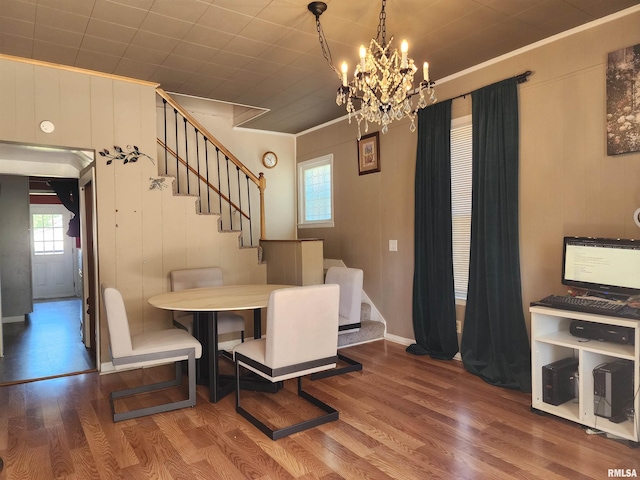 dining room featuring stairway, wood finished floors, healthy amount of natural light, and ornamental molding