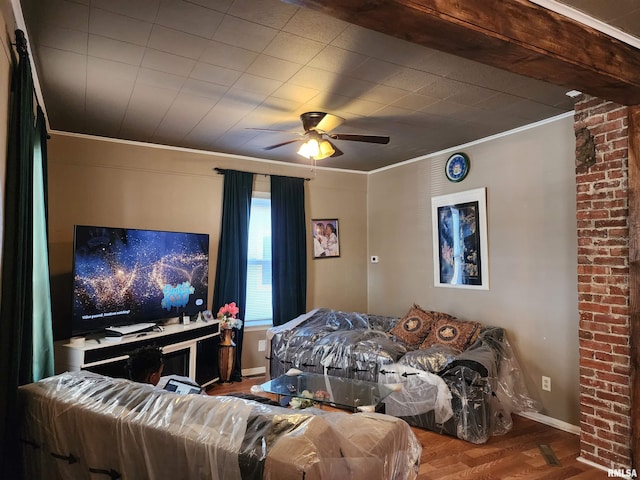 bedroom featuring ornamental molding, wood finished floors, baseboards, and a ceiling fan