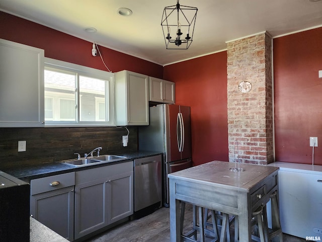 kitchen with stainless steel dishwasher, a sink, dark countertops, and pendant lighting