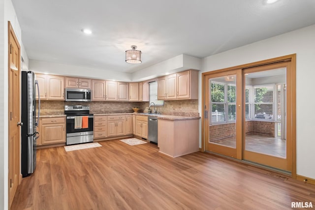 5021 Wildcat Run, Springfield, IL 62711 - kitchen with appliances with stainless steel finishes, light brown cabinets, a sink, light wood finished floors, and tasteful backsplash