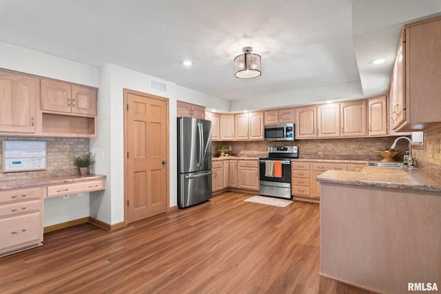 5021 Wildcat Run, Springfield, IL 62711 - kitchen featuring stainless steel appliances, a sink, light brown cabinetry, backsplash, and light wood-type flooring