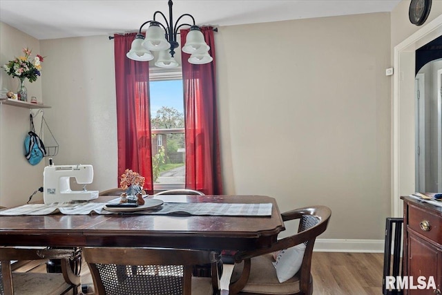 dining area with a chandelier, light wood-type flooring, and baseboards