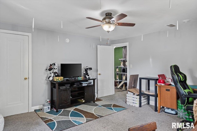 carpeted living area featuring a ceiling fan and baseboards