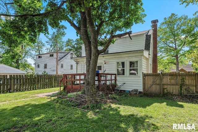 rear view of house featuring a chimney and a deck