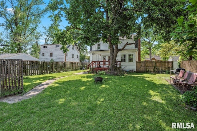back of house with a deck and an outdoor fire pit