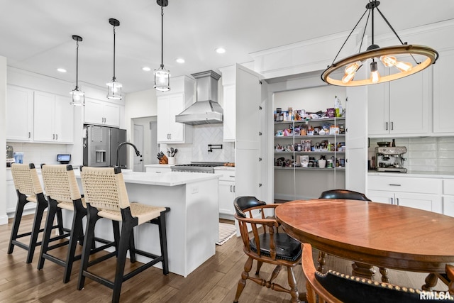 1915 Parthenon Ct, Chatham, IL 62629 - kitchen with wall chimney range hood, stainless steel refrigerator with ice dispenser, tasteful backsplash, light countertops, and recessed lighting