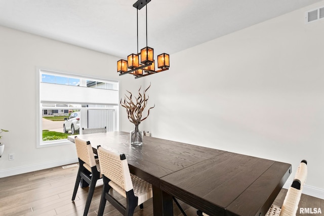 1915 Parthenon Ct, Chatham, IL 62629 - dining area featuring a chandelier, wood finished floors, and baseboards