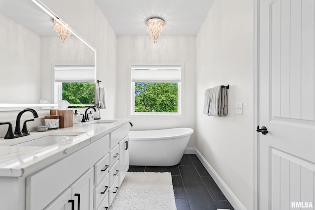 1915 Parthenon Ct, Chatham, IL 62629 - full bath featuring a freestanding tub, a chandelier, tile patterned floors, double vanity, and baseboards