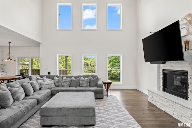 1915 Parthenon Ct, Chatham, IL 62629 - living room with a towering ceiling, dark wood-style floors, a fireplace, healthy amount of natural light, and baseboards
