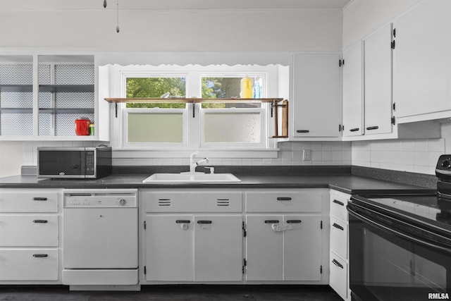 kitchen featuring black range with electric stovetop, dishwasher, stainless steel microwave, a sink, and dark countertops