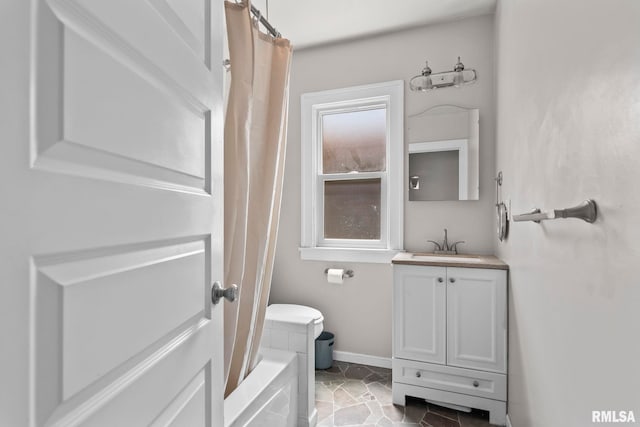 full bathroom with vanity and baseboards