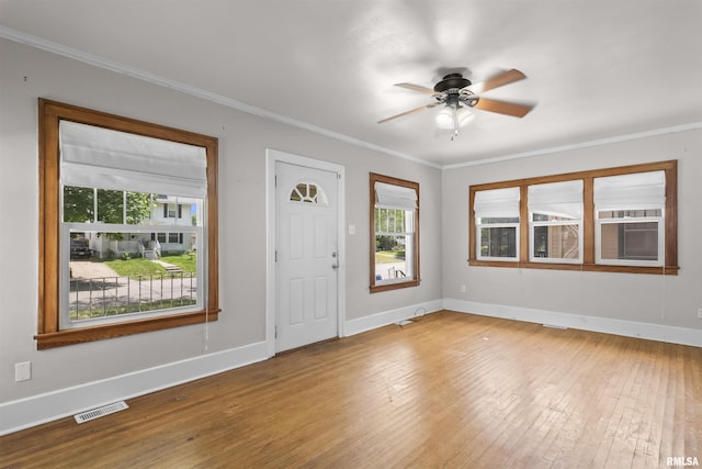 foyer entrance featuring wood-type flooring, ceiling fan, ornamental molding, and baseboards