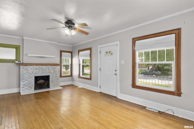 unfurnished living room featuring ceiling fan, light wood-type flooring, healthy amount of natural light, baseboards, and crown molding