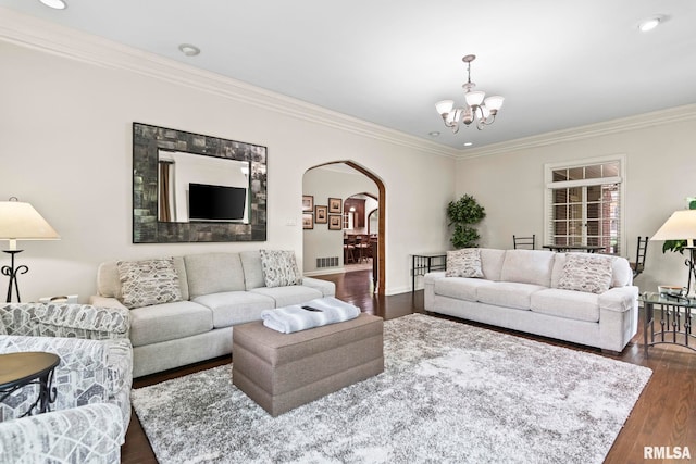 living area with arched walkways, crown molding, dark wood-style flooring, a chandelier, and baseboards