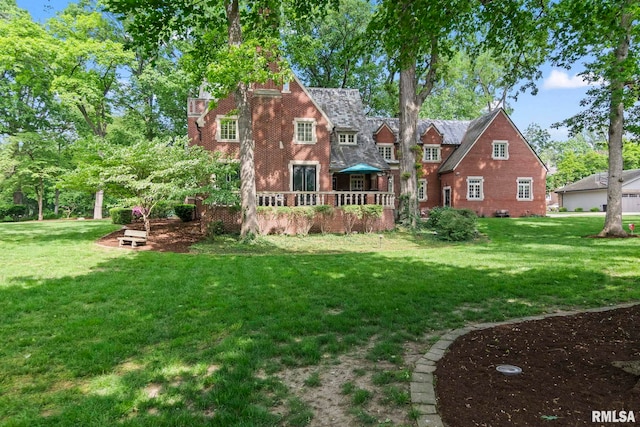 back of property with a lawn and a deck