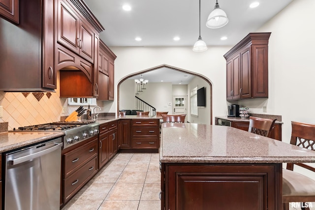kitchen with stainless steel appliances, arched walkways, recessed lighting, tasteful backsplash, and hanging light fixtures